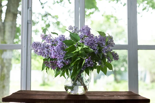 玻璃瓶里的紫丁香束 白色桌布桌上的紫丁香束 — 图库照片