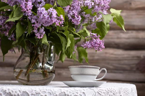 丁香花束和一杯茶 热饮料 — 图库照片