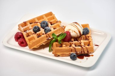 Tatlı tabağı. Dondurma, yaban mersini ve ahududu ile Belçika waffle 'ı.