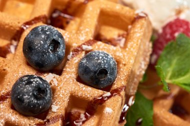 Tatlı tabağı. Dondurma, yaban mersini ve ahududu ile Belçika waffle 'ı.