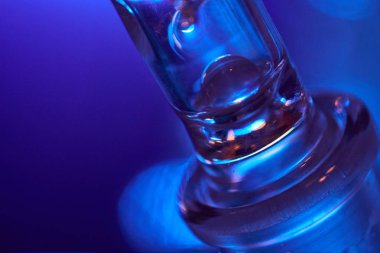 Mavi arka planda cam ampul. Bardağın soyut fotoğrafı..