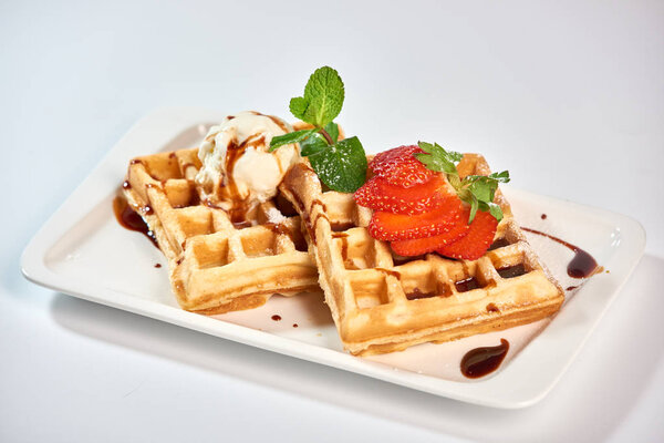 Belgian waffles with strawberries./Belgian waffles with ice cream, strawberries and raspberries.