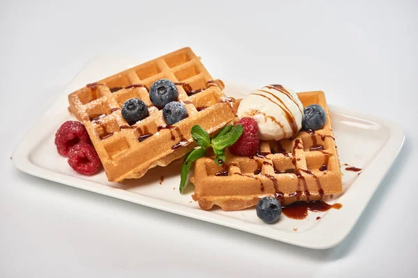 Tatlı tabağı. Dondurma, yaban mersini ve ahududu ile Belçika waffle 'ı.