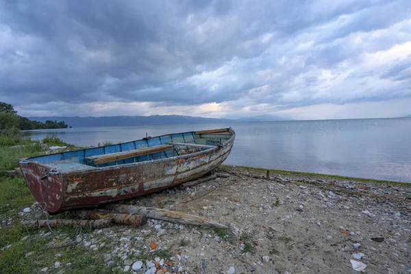 Ohri Gölü manzaraları ve sahilde yıkanmış tekne Stok Resim