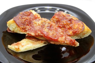 Siyah tabakta pizza kesiği. Siyah bir tabaküzerinde pizza dilimi.