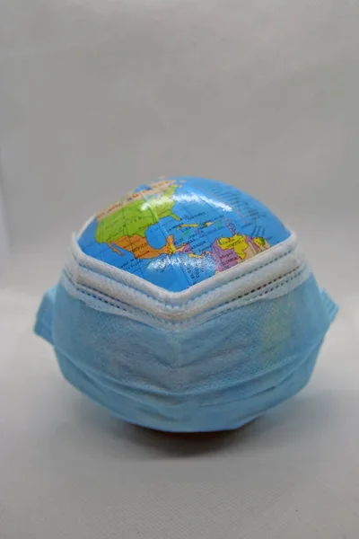World wearing protective mask. Globe with a surgical mask. Covid protection.