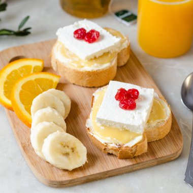 Tereyağı, bal ve yumuşak peynir ile bir sandviç. Sağlıklı ve lezzetli bir kahvaltı kavramı.
