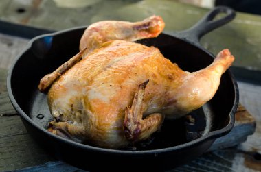 Bütün tavuk ve bir ahşap zemin üzerine kavrulmuş.