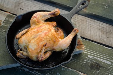 Bütün tavuk ve bir ahşap zemin üzerine kavrulmuş.