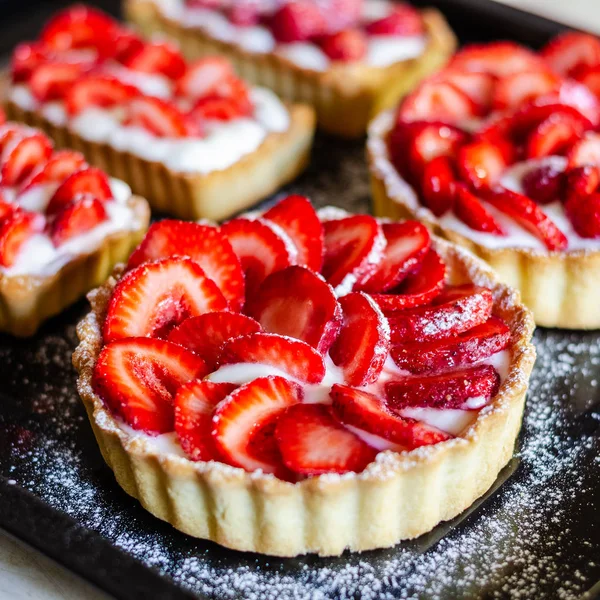Strawberry shortcake pies (Strawberries tartlet) on black background, perfect party individual fresh fruit dessert