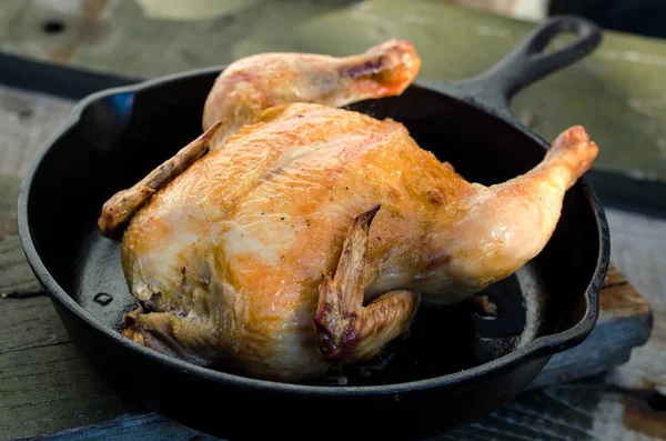 Bütün tavuk ve bir ahşap zemin üzerine kavrulmuş.