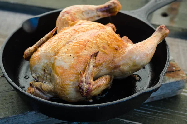 Bütün tavuk ve bir ahşap zemin üzerine kavrulmuş.