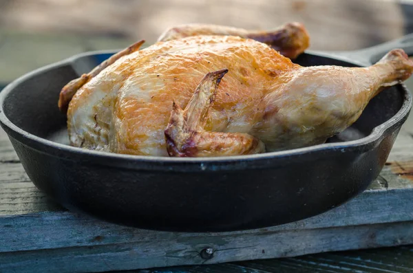 Bütün tavuk ve bir ahşap zemin üzerine kavrulmuş.