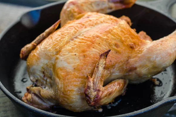 Bütün tavuk ve bir ahşap zemin üzerine kavrulmuş.