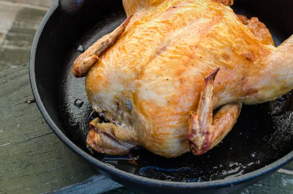 Bütün tavuk ve bir ahşap zemin üzerine kavrulmuş.