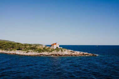 Lighthouse on rocky shore. Island of Vis, Croatia  clipart
