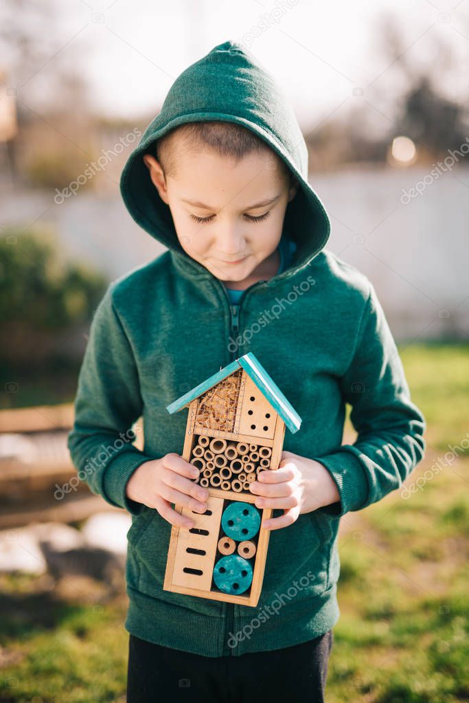 Boy holding insect hotel made from wood