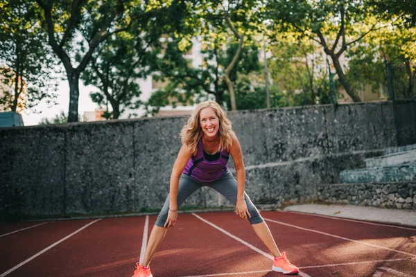 40 'lı yaşlarda orta yaşlı bir kadın dışarıda eğitim görüyor.