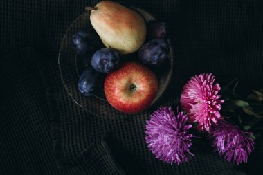 Karanlık bir meyve ve çiçekte durgun bir hayat