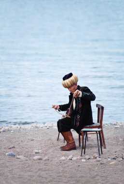 Kırgızistan'da İssil Kul'da Komuz'u oynayan adam