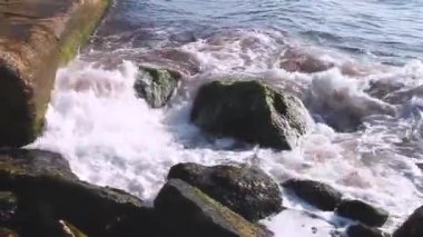 gündüz dalga sıçraması ile kayalık kıyı 