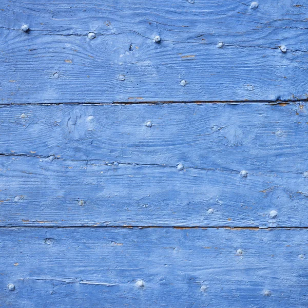 Helder blauw geschilderd oude houten planken met scheuren en nagels — Stockfoto