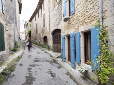 Yalnız figür ve panjurlar ve bitki manosque içinde ev ile eski sokak