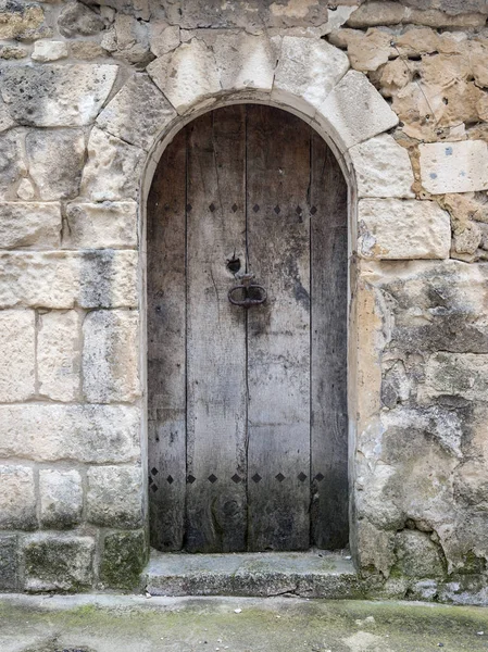 çok eski karanlık ahşap kapı evin Fransa antik kireçtaşı duvarındaki kemerli