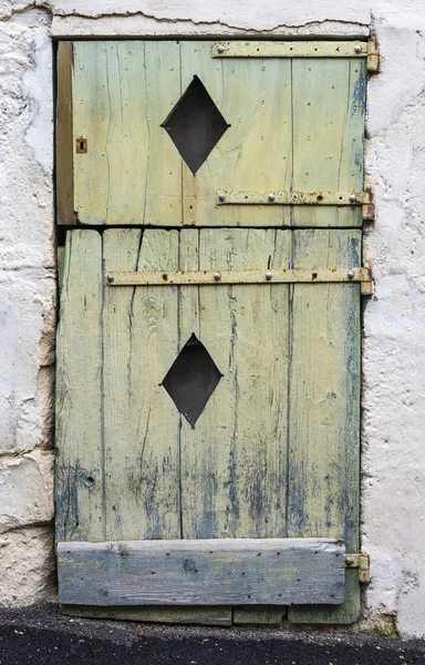 Bardzo stare drzwi zielony z peeling farby i rombowy otworów w drewnie — Zdjęcie stockowe