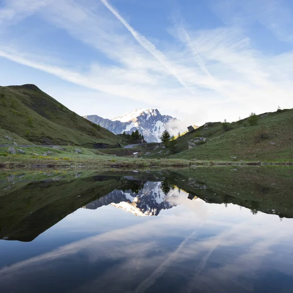 Snow capped mountain reflected in water of small lake near col de vars in french alps — Stock Photo, Image