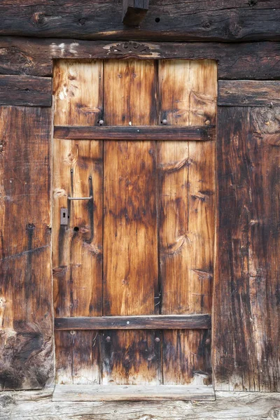 Closeup of very old brown wooden weathered planks of door in swiss barn — Stock Photo, Image