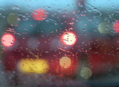 renkli ışık ve yağmur damlaları winshield arabanın hava karardıktan sonra sağanak sırasında soyut desen