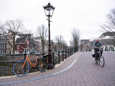 Amsterdam, Hollanda, 10 Ocak 2010: bisiklet ve prinsengracht ve Amsterdam'da reguliersgracht köşesinde köprülerde merkezi bulutlu kış gününde