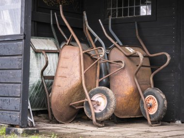 bahar aylarında kullanılmak üzere bekleyen kışın eski kahverengi paslı el arabası döken
