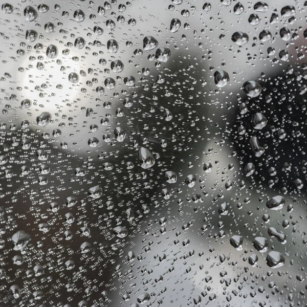 雨のシャワーの間に車のフロント ガラスのガラス ウィンドウに雨粒 — ストック写真