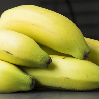 kare closeup gri koyu arka plan üzerinde beş sarı muz