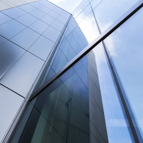 Detail eines modernen Bürogebäudes mit Glas und Stahl, das den blauen Himmel reflektiert — Stockfoto