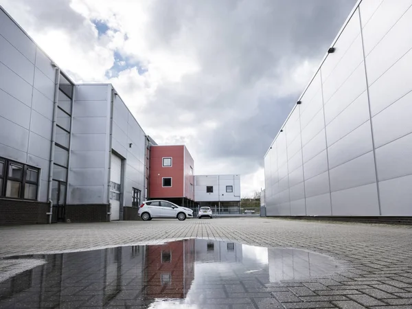 Industriegebiet mit Pfütze nach Regen und Autos — Stockfoto