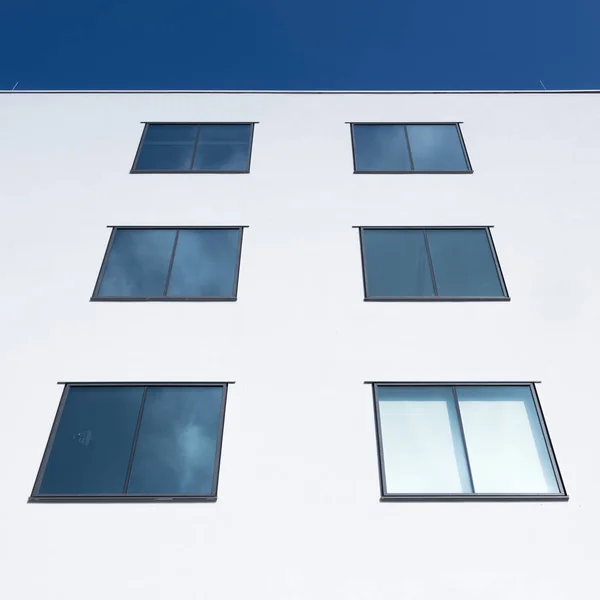 Abstrakte rechteckige Formen von Fenstern in weißer Wand reflektieren Blau — Stockfoto