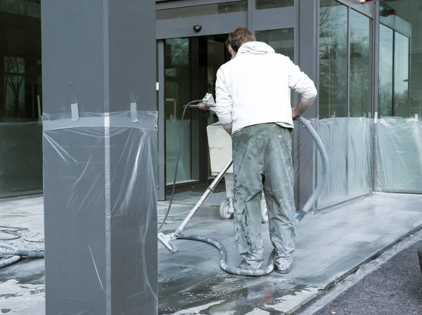 Man reinigt en poetsmiddelen marmeren vloer van kantoorgebouw — Stockfoto