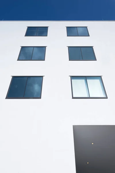 Formes rectangulaires abstraites de fenêtres en mur blanc reflètent bleu — Photo