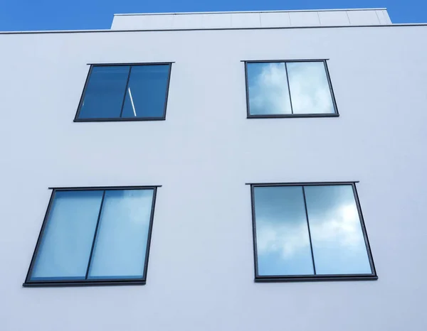 Formes rectangulaires abstraites de fenêtres en mur blanc reflètent bleu — Photo