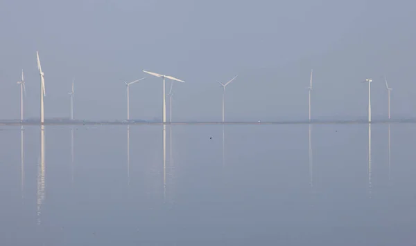 Wind turbines and blue sky reflected in water of eemmeer near hu — Stock Photo, Image