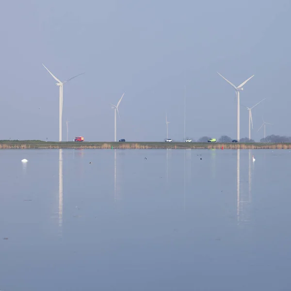 Ветряные турбины и голубое небо отражаются в воде Иммера вблизи Ху — стоковое фото