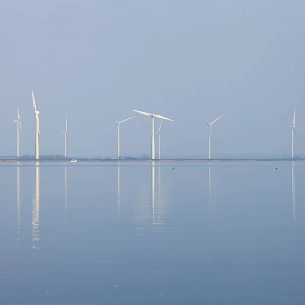 Turbin angin dan langit biru tercermin dalam air eemmeer dekat hu — Stok Foto