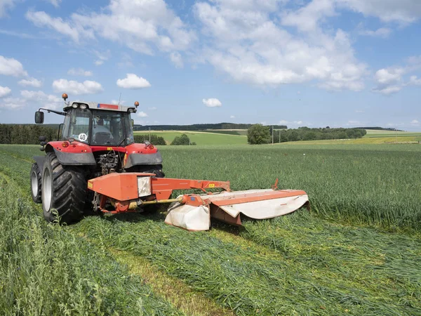 Granjero belga corta hierba con tractor en el campo cerca de Lieja en th — Foto de Stock