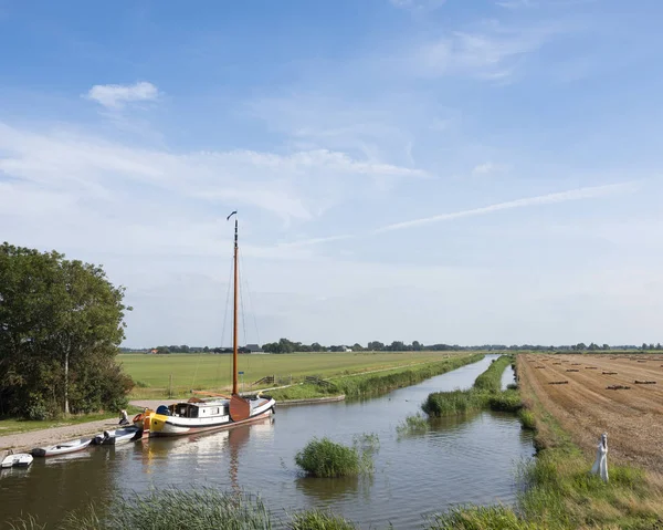 Gente y barcos en el canal del típico paisaje frisón en el no — Foto de Stock