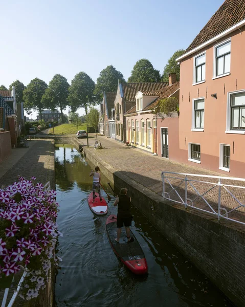 Hollandaca eski şehir dokkum kanalında sörf tahtaları kürek kızlar — Stok fotoğraf