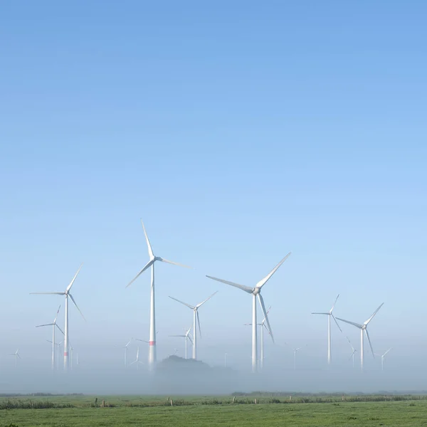 Wind turbines in green meadow near aurich in ostfriesland on mis — Stock Photo, Image