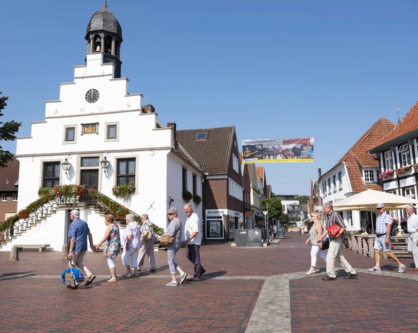 Los turistas mayores pasan por el antiguo ayuntamiento en la plaza del mercado en remolque alemán — Foto de Stock